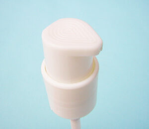 White plastic pump SNXC0202 Personal care and cosmetic pump with a textured top for improved grip and squeezing process.